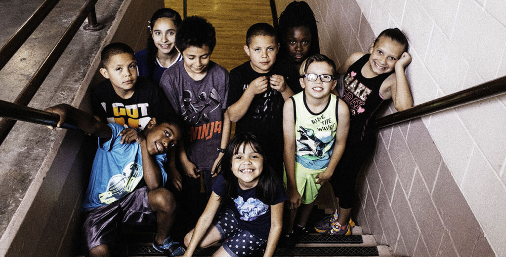 group of kids smiling on stairs