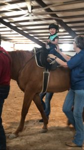 a child on a horse and handlers